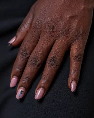 Mão com unhas compridas pintadas de rosa velho